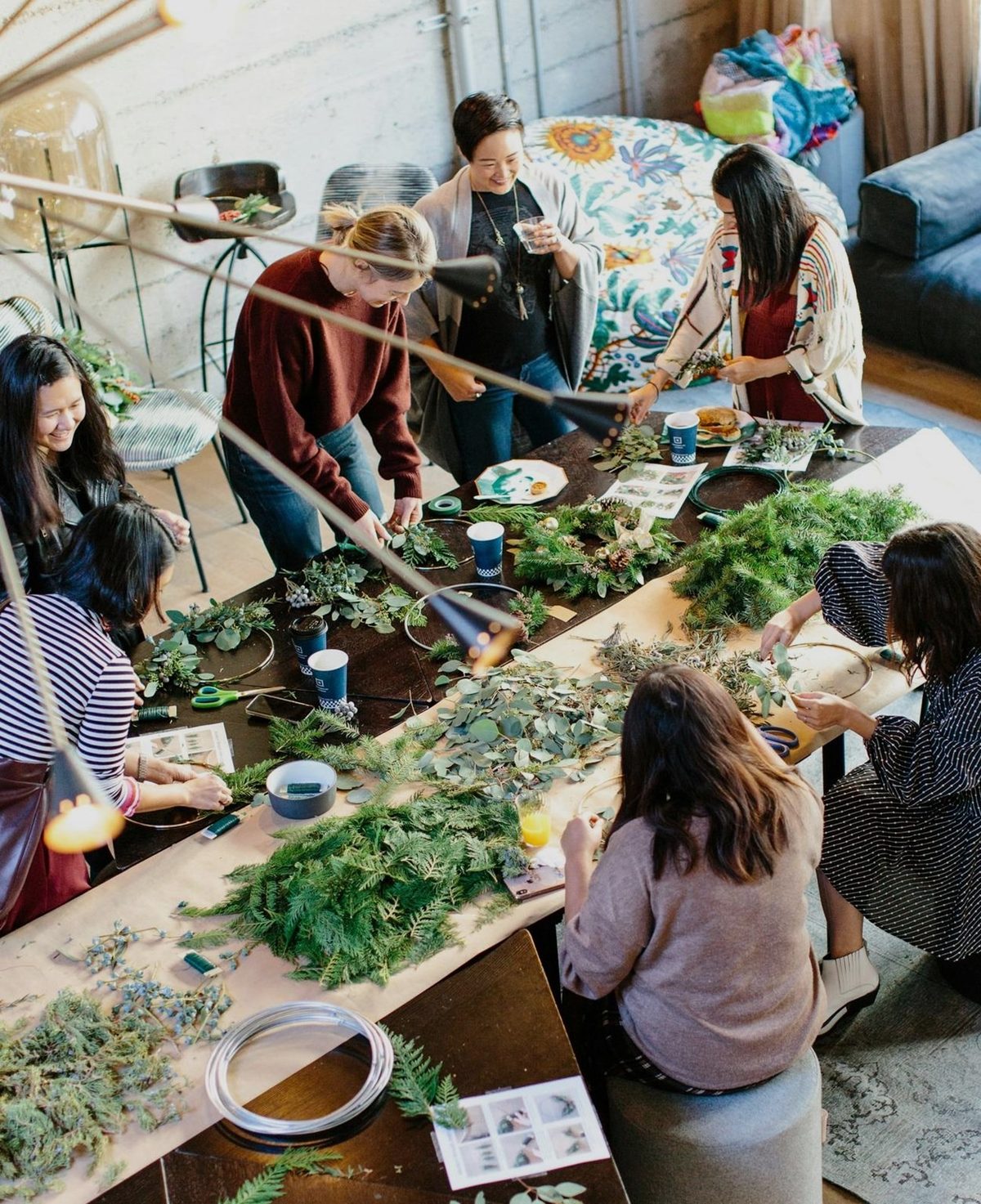 Students and community members collaborating around a shared worktable
